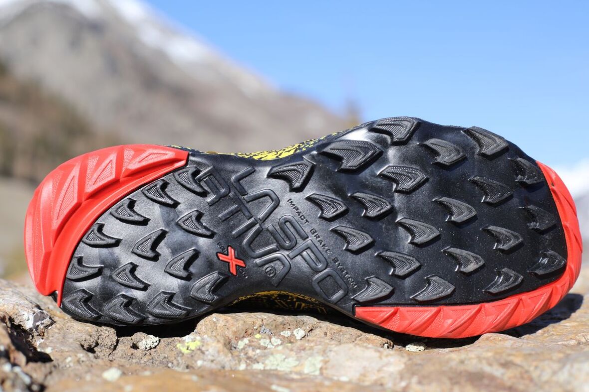 Подошва кроссовок La Sportiva Akasha, ориентированных на горные трейлы. Красные вставки сделаны из более мягкой резины и улучшают сцепление на подъёмах и спусках. Источник: irunfar.com Подошва кроссовок La Sportiva Akasha, ориентированных на горные трейлы. Красные вставки сделаны из более мягкой резины и улучшают сцепление на подъёмах и спусках. Источник: irunfar.com